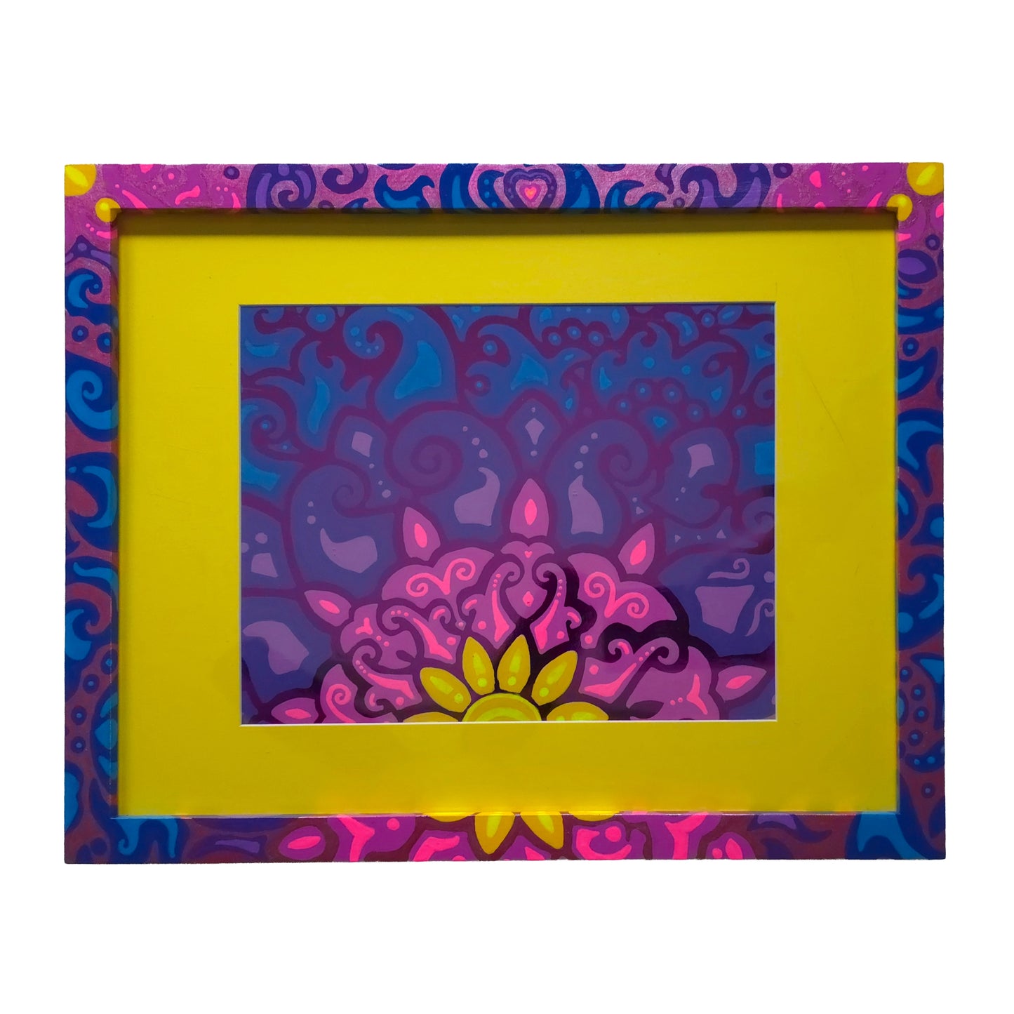 A framed art print featuring a vibrant, colorful mandala design with pink, purple, and blue swirls, surrounded by a thick bright yellow mat and a decorative patterned frame.