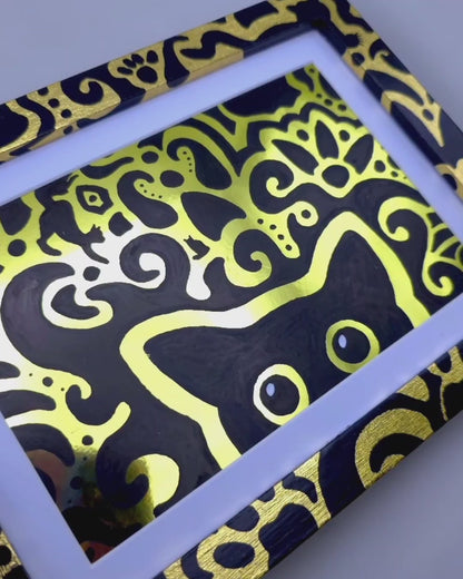 Angled view of the shift supervisor artwork with a gold foil background, gold leaf frame and cat themed