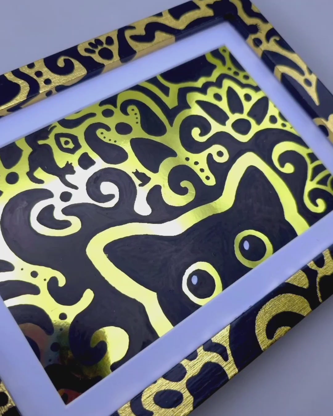 Angled view of the shift supervisor artwork with a gold foil background, gold leaf frame and cat themed