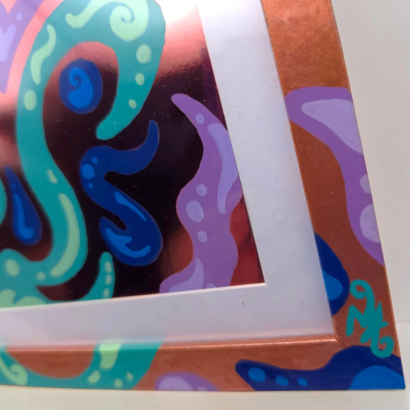 Close-up of a colorful abstract art print or poster showing a corner with teal, blue, purple, and brown organic shapes around a white mat border.